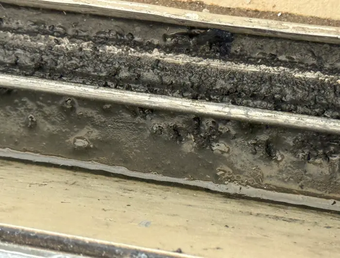 Dirty sliding door lower track before repair