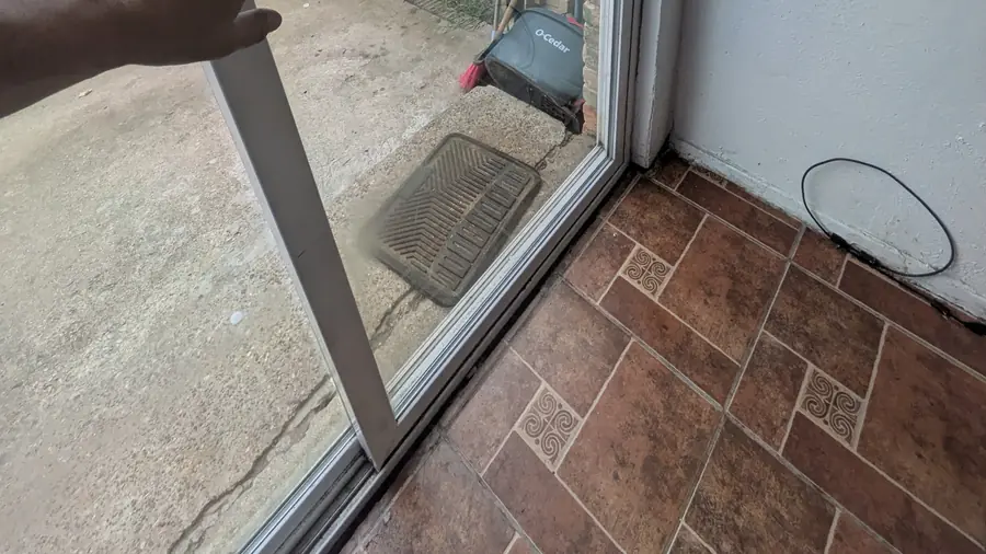 Hand sliding a patio door panel in an open doorway