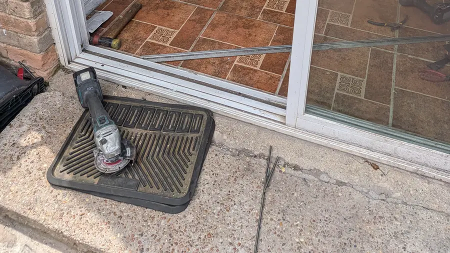 Sliding glass door panel sitting open near the lower track