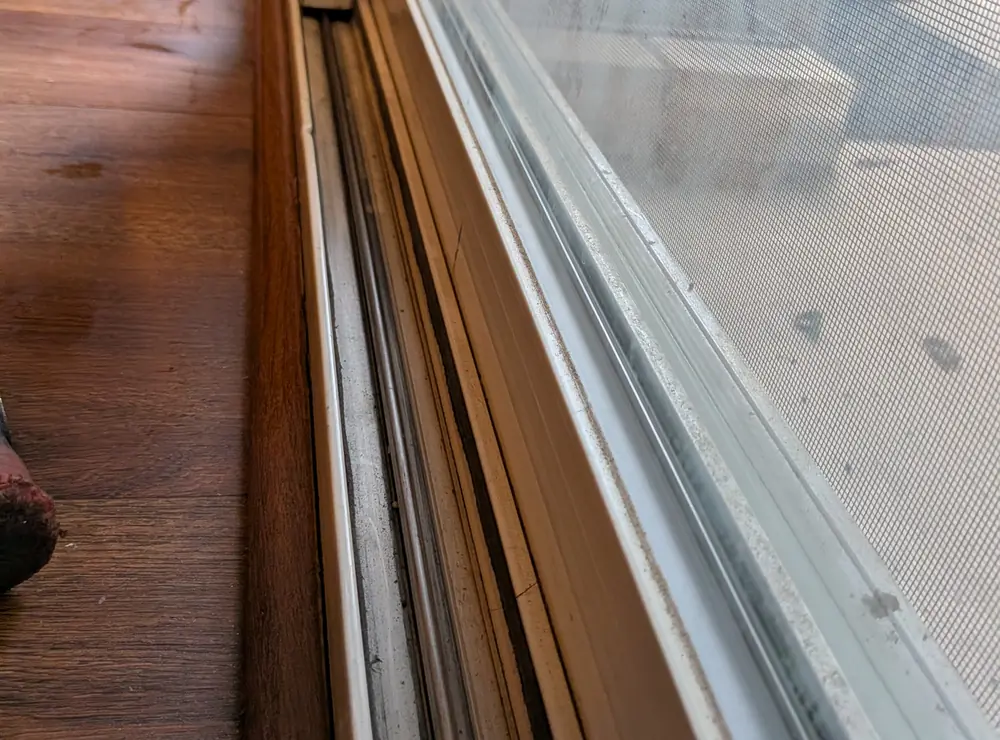 Sliding patio door lower track, panel gap, and track area used for alignment checks