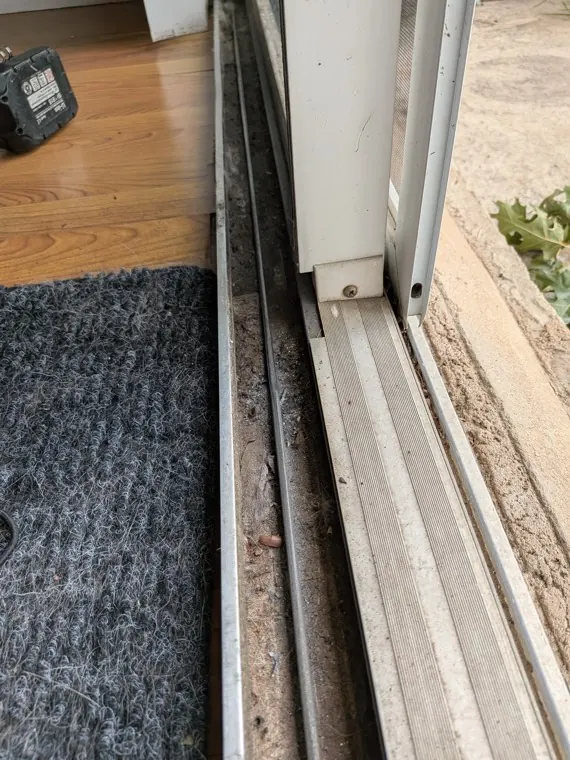 Real sliding door lower track and threshold where the panel rides