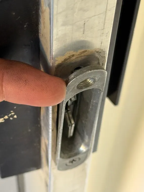 Close-up of a real sliding door latch and keeper area