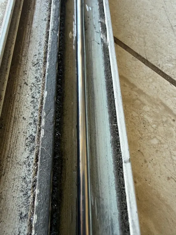 Real lower track channel with uneven buildup where the door slides